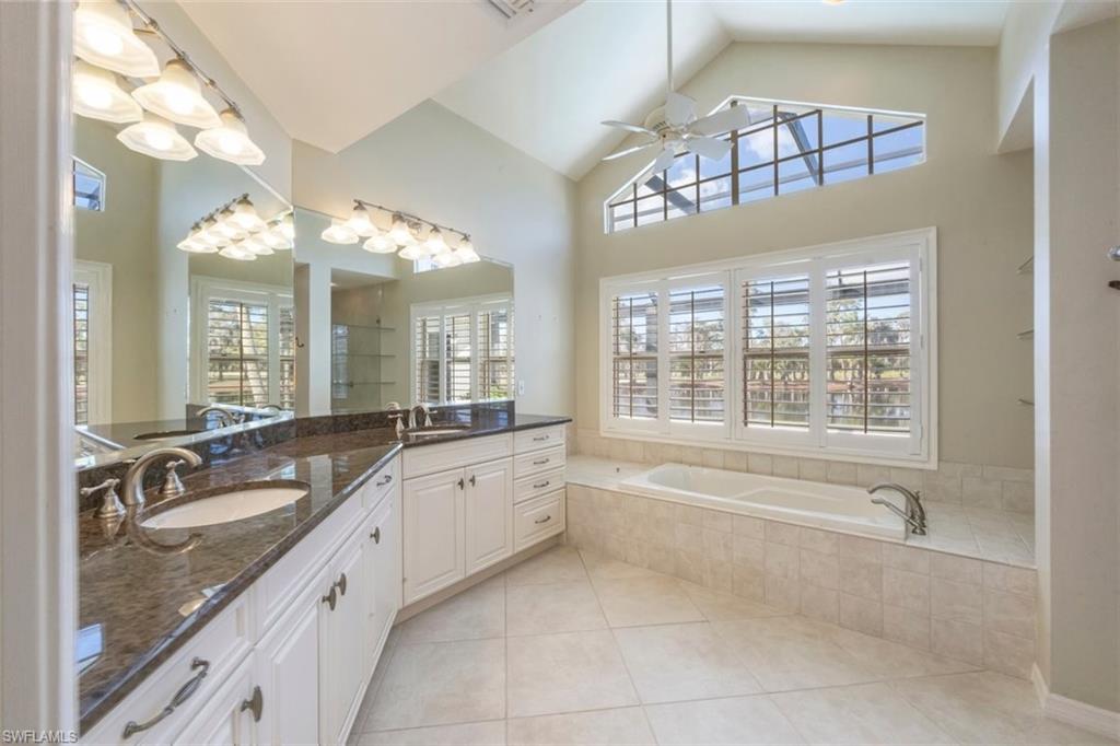 25 Grey Wing Point Naples, FL 34113 - Photo 16 of 25 a large bathroom with a granite countertop tub a double vanity sink a vanity and a large mirror