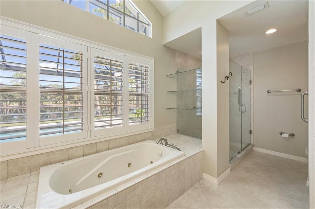 25 Grey Wing Point Naples, FL 34113 - Photo 17 of 25 a bathroom with a tub a sink and a large window