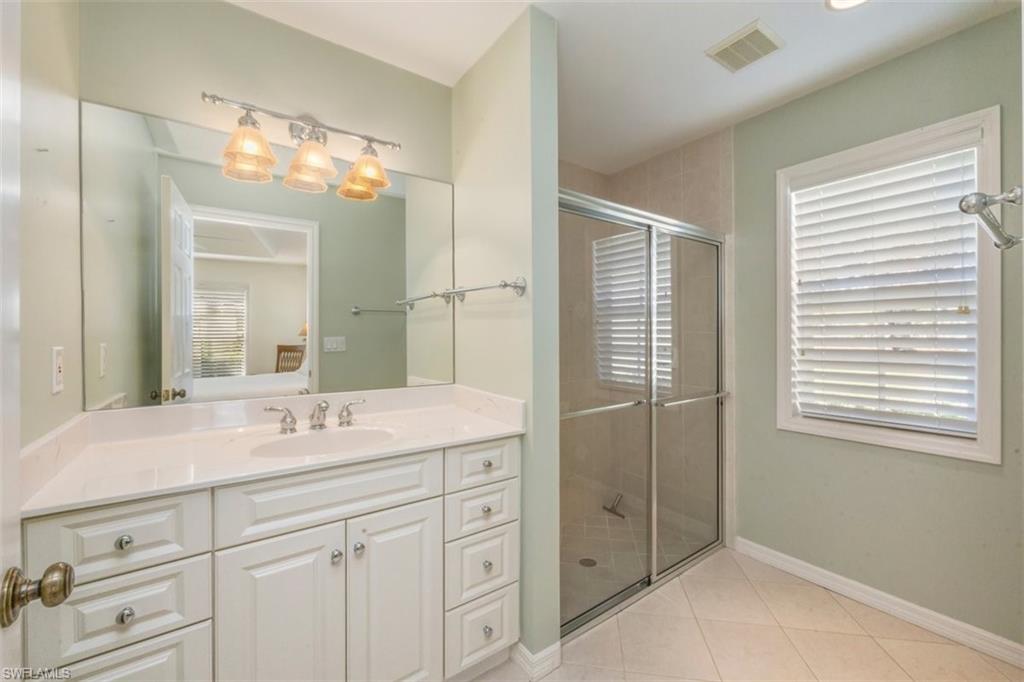 25 Grey Wing Point Naples, FL 34113 - Photo 22 of 25 a bathroom with a shower sink and mirror