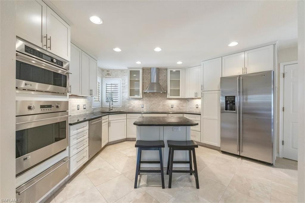 25 Grey Wing Point Naples, FL 34113 - Photo 9 of 25 a kitchen with a refrigerator and a sink