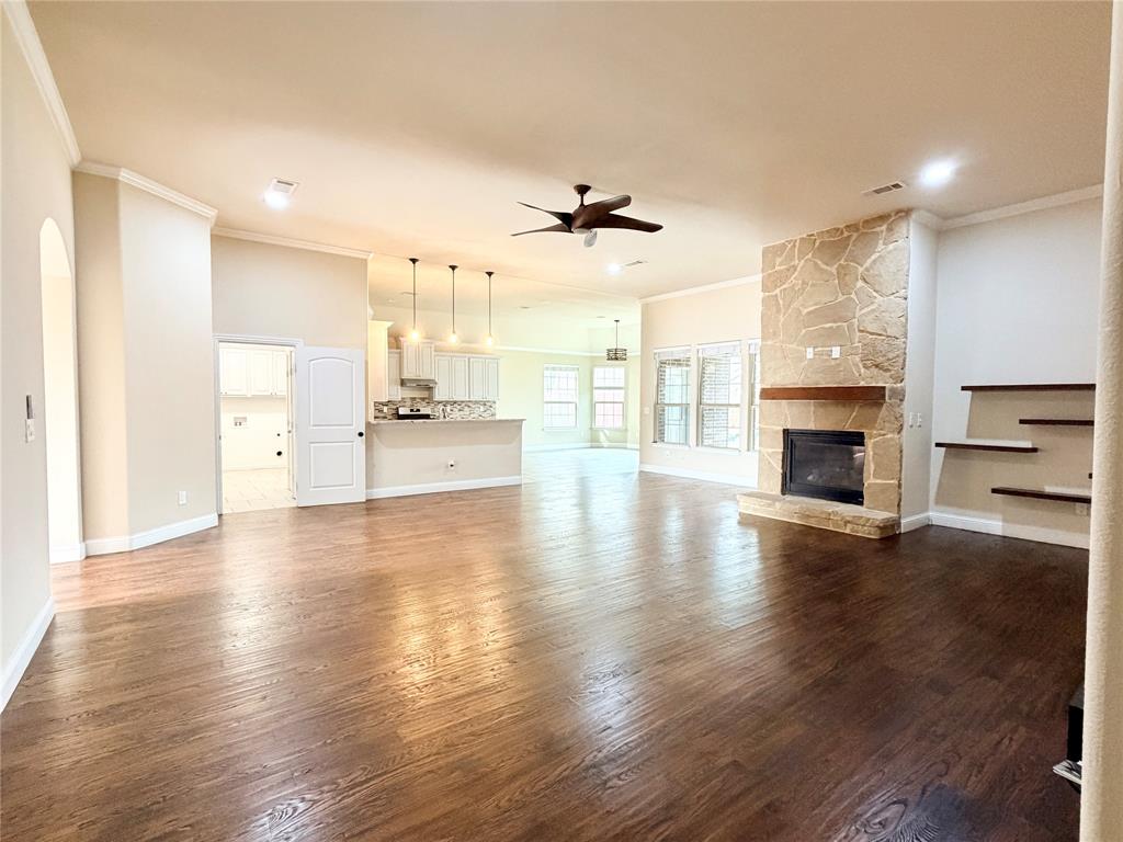501 Elwood Road Irving, TX 75061 - Photo 5 of 30 an empty room with wooden floor fireplace and windows