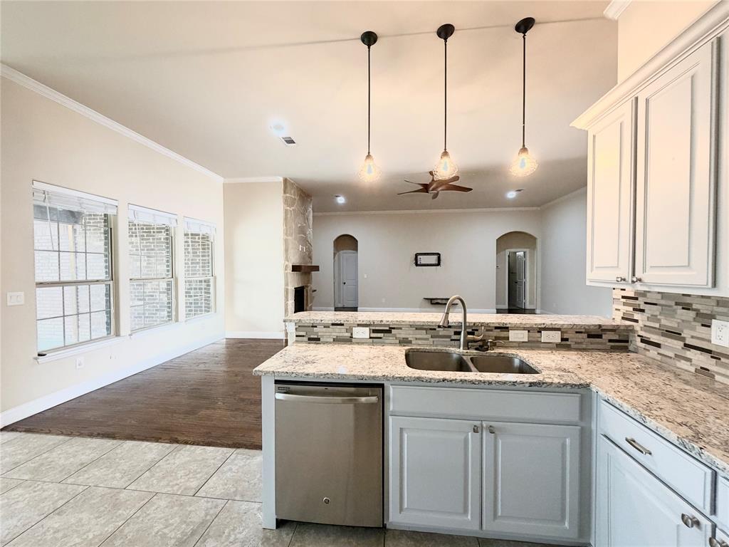501 Elwood Road Irving, TX 75061 - Photo 10 of 30 a kitchen with kitchen island granite countertop a sink a stove and cabinets