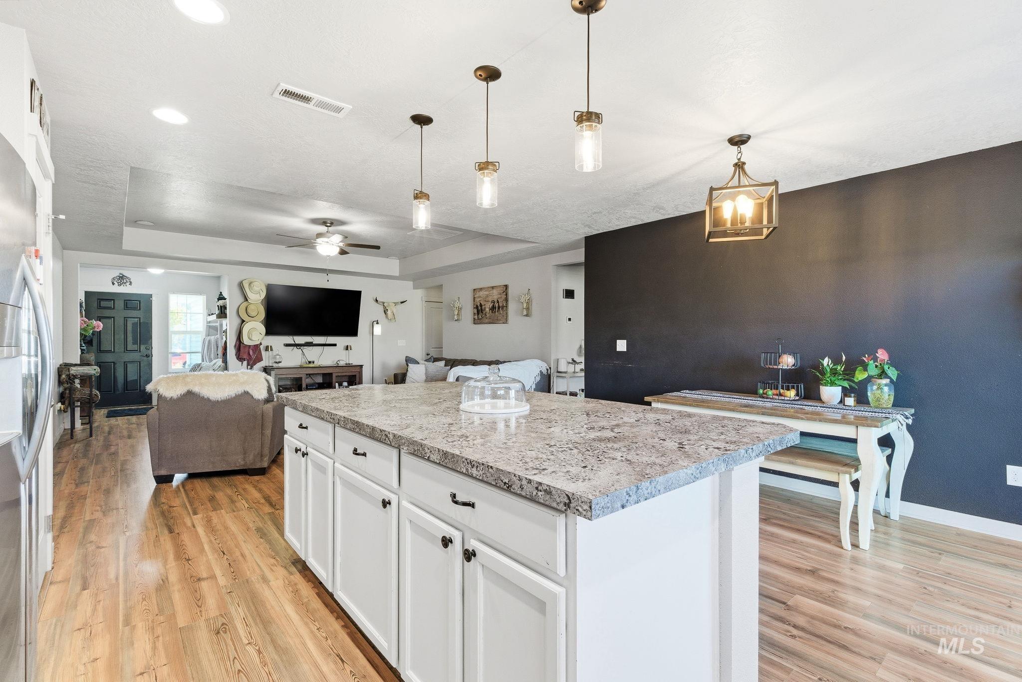 16887 Bethany Avenue Caldwell, ID 83607 - Photo 21 of 50 Kitchen island featuring a light-toned countertop, white cabinetry, and brushed nickel hardware