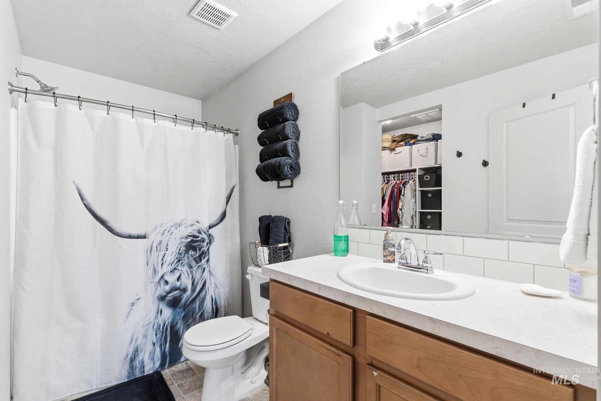 16887 Bethany Avenue Caldwell, ID 83607 - Photo 32 of 50 Bathroom featuring a built-in vanity with wood-finish cabinetry, a white countertop, and an integrated sink