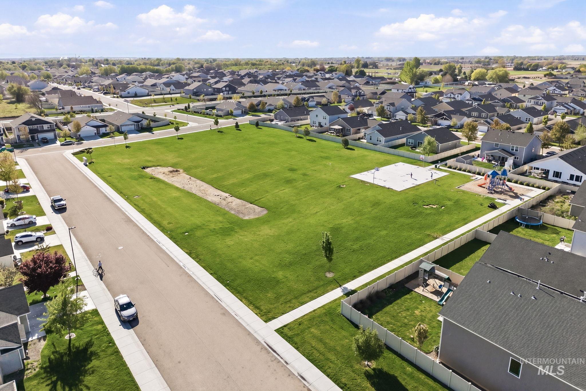 16887 Bethany Avenue Caldwell, ID 83607 - Photo 39 of 50 Expansive community green space featuring manicured lawns, a sand volleyball court, and a playground structure