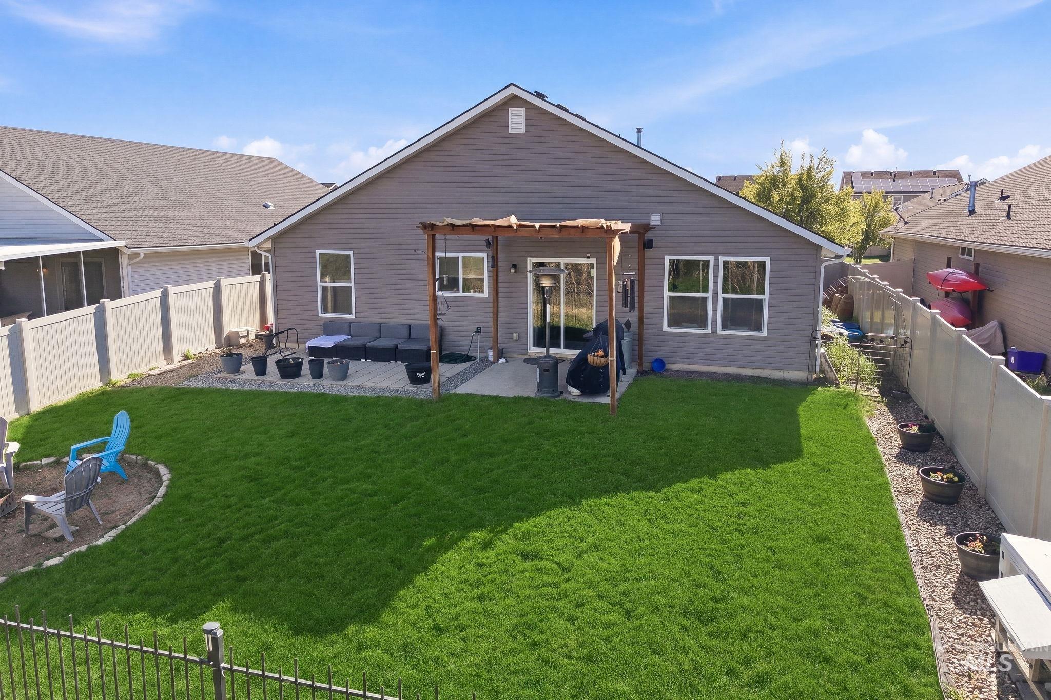 16887 Bethany Avenue Caldwell, ID 83607 - Photo 41 of 50 Expansive backyard featuring a lush lawn, privacy fencing, and a paver patio with a pergola