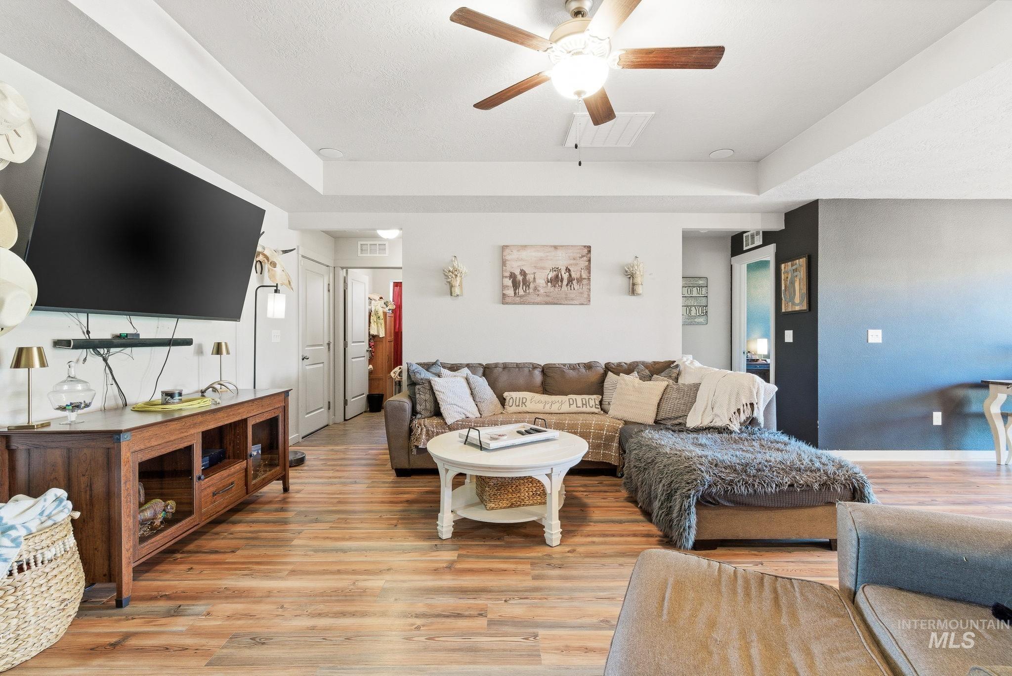 16887 Bethany Avenue Caldwell, ID 83607 - Photo 8 of 50 Living area featuring wood-finish flooring and a tray ceiling with a ceiling fan