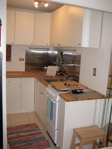 a kitchen with a sink a stove and cabinets