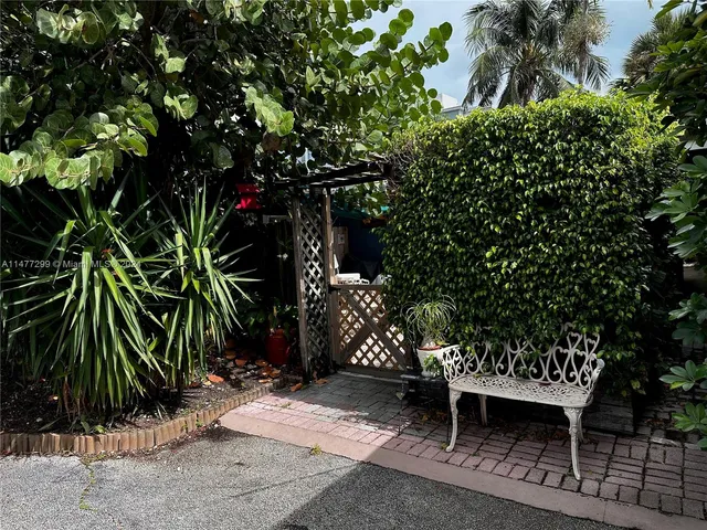 a couple of table and chairs in the patio next to a road