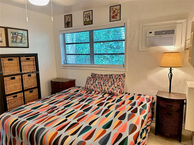 a bedroom with a bed and a lamp on dresser