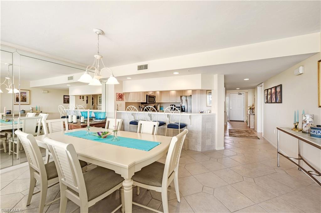 21 Bluebill Avenue, Unit 403B Naples, FL 34108 - Photo 11 of 37 a dining room with furniture a chandelier and kitchen view