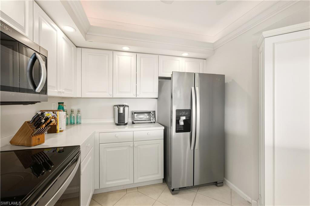 21 Bluebill Avenue, Unit 403B Naples, FL 34108 - Photo 14 of 37 a kitchen with a refrigerator sink and cabinets