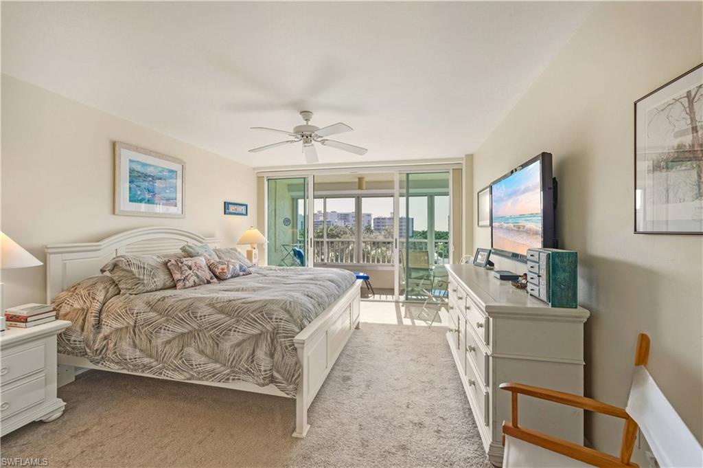 21 Bluebill Avenue, Unit 403B Naples, FL 34108 - Photo 16 of 37 a spacious bedroom with a bed and a flat screen tv