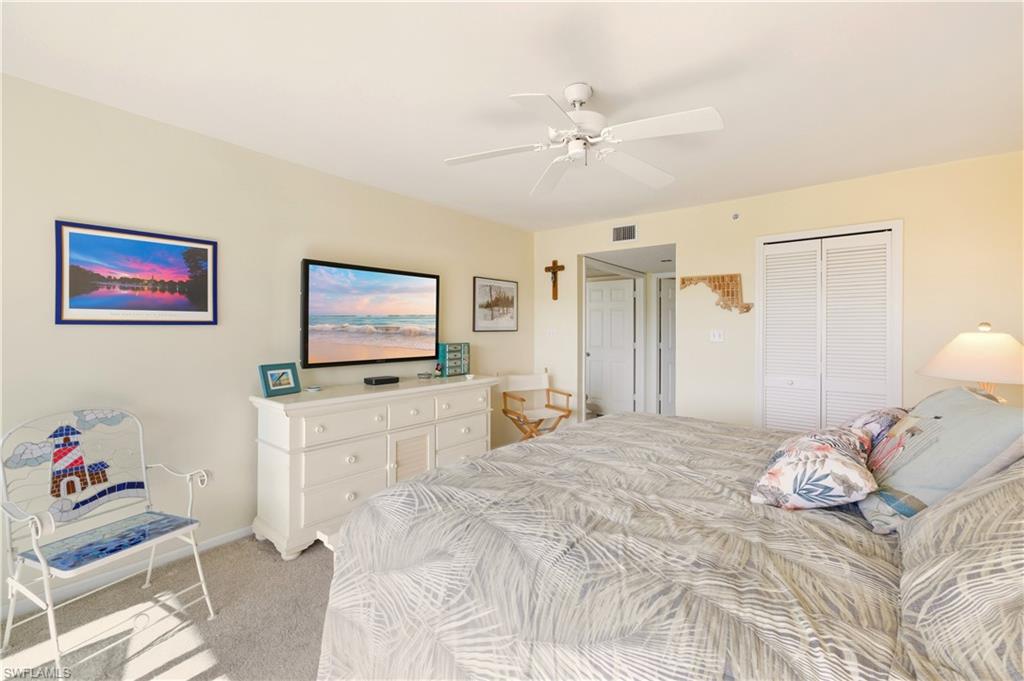 21 Bluebill Avenue, Unit 403B Naples, FL 34108 - Photo 18 of 37 a bedroom with a bed and a flat screen tv