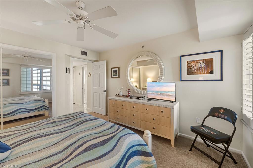 21 Bluebill Avenue, Unit 403B Naples, FL 34108 - Photo 23 of 37 a bedroom with a bed and a chair