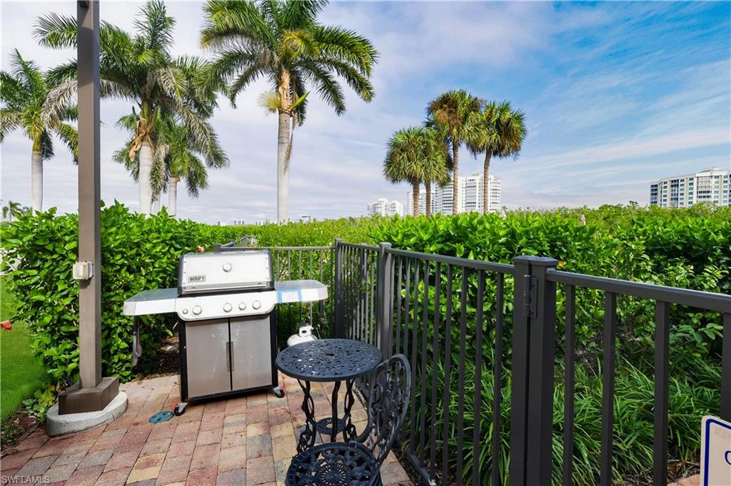 21 Bluebill Avenue, Unit 403B Naples, FL 34108 - Photo 31 of 37 a view of a chair and table in the garden