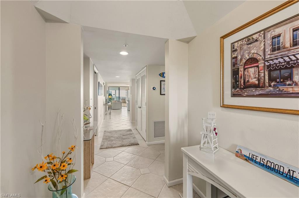 21 Bluebill Avenue, Unit 403B Naples, FL 34108 - Photo 4 of 37 a hallway with a dining table and chairs