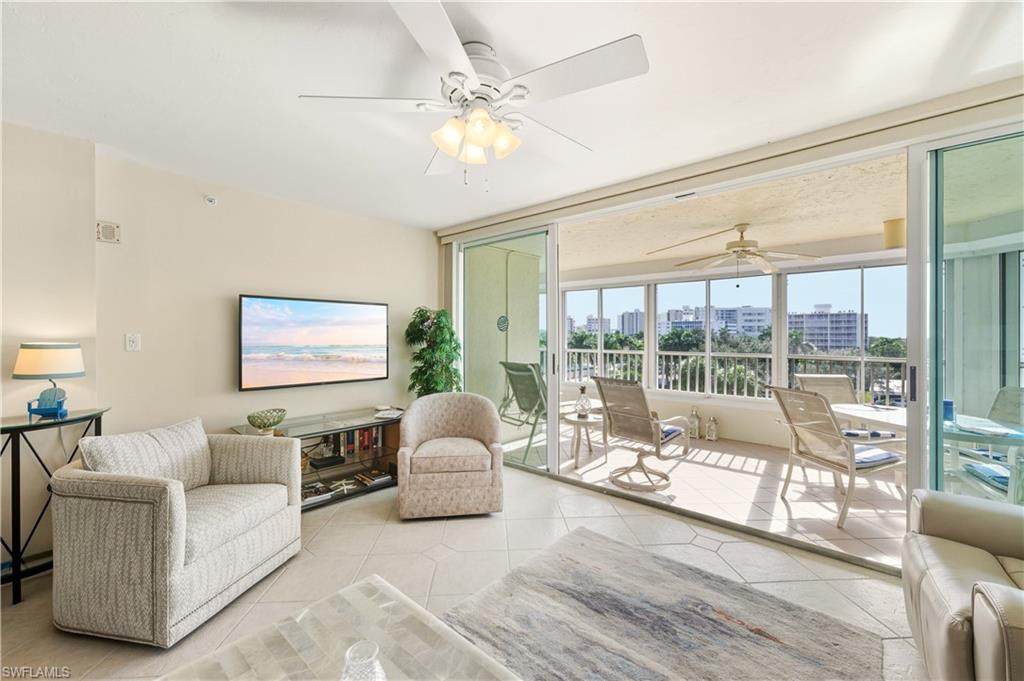 21 Bluebill Avenue, Unit 403B Naples, FL 34108 - Photo 8 of 37 a living room with furniture and a large window with outer view