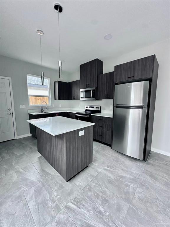 3800 Robin Street, Unit 2 Pharr, TX 78577 - Photo 2 of 18 a kitchen with stainless steel appliances granite countertop a refrigerator a stove a sink and a microwave