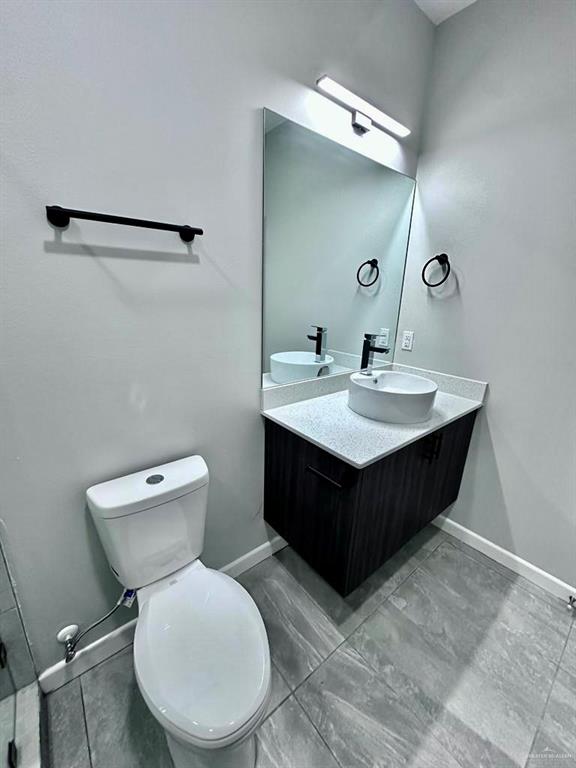 3800 Robin Street, Unit 2 Pharr, TX 78577 - Photo 10 of 18 a bathroom with a toilet a sink and mirror