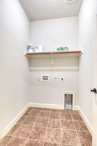 a view of a refrigerator in kitchen and an empty room