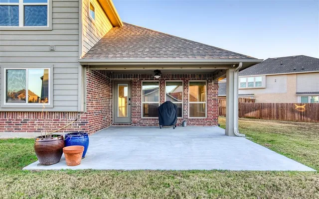 a view of a backyard with table and chairs and a barbeque