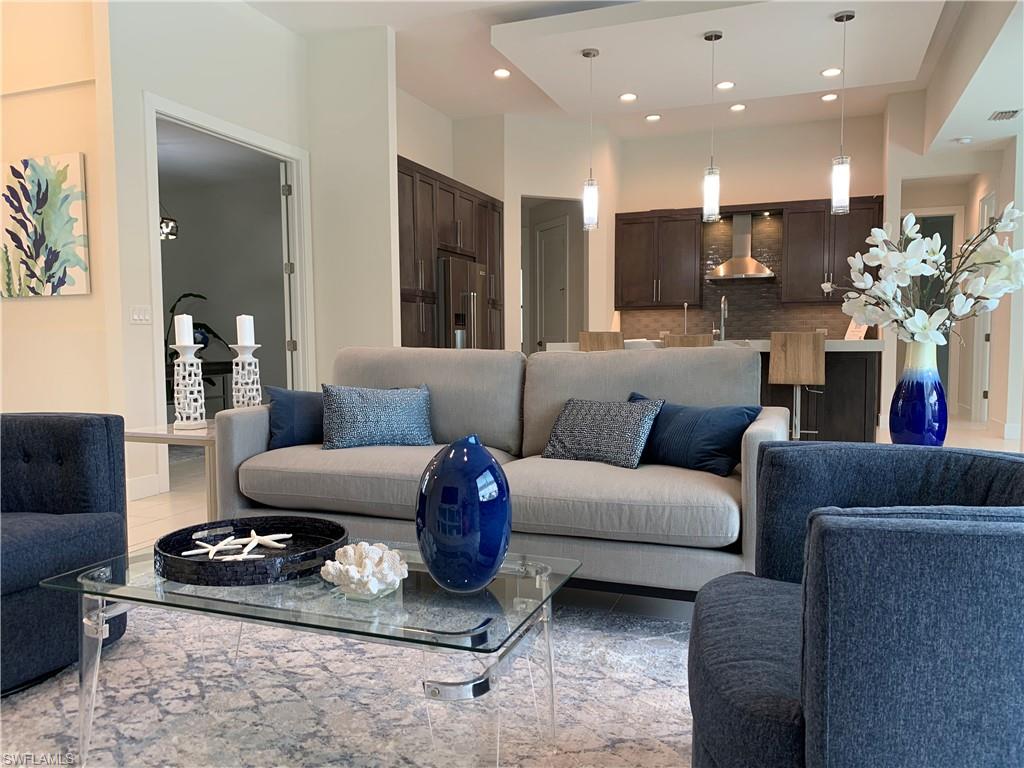 a living room with furniture kitchen and a chandelier