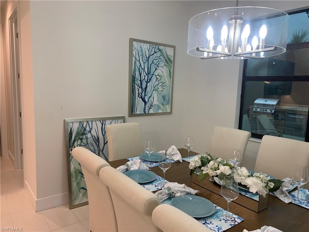 214 Legacy Court Naples, FL 34110 - Photo 16 of 49 a dining room with furniture and chandelier