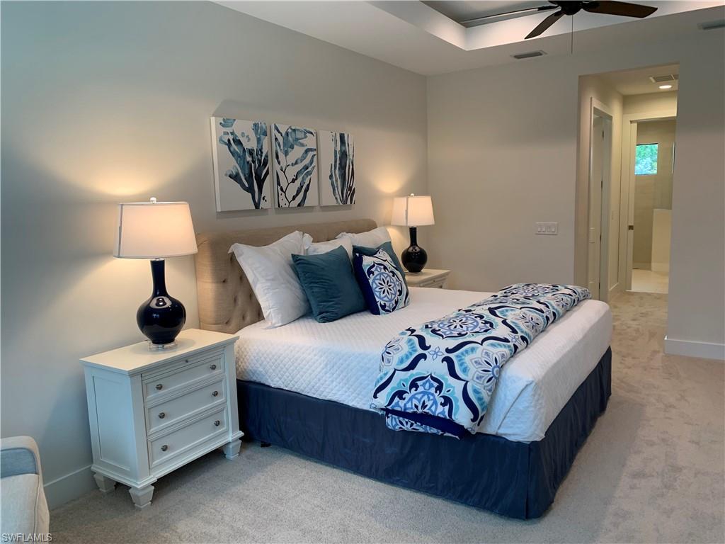 214 Legacy Court Naples, FL 34110 - Photo 22 of 49 a bedroom with a bed and a lamp