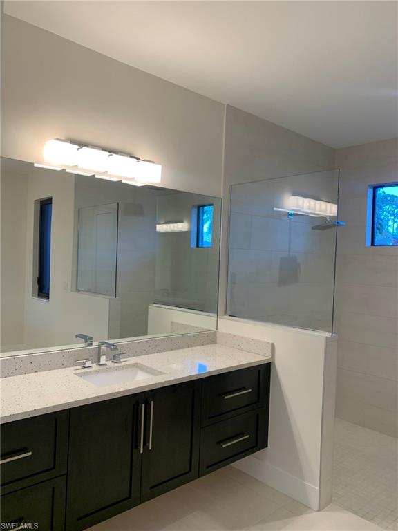 214 Legacy Court Naples, FL 34110 - Photo 29 of 49 a bathroom with a double vanity sink and a mirror
