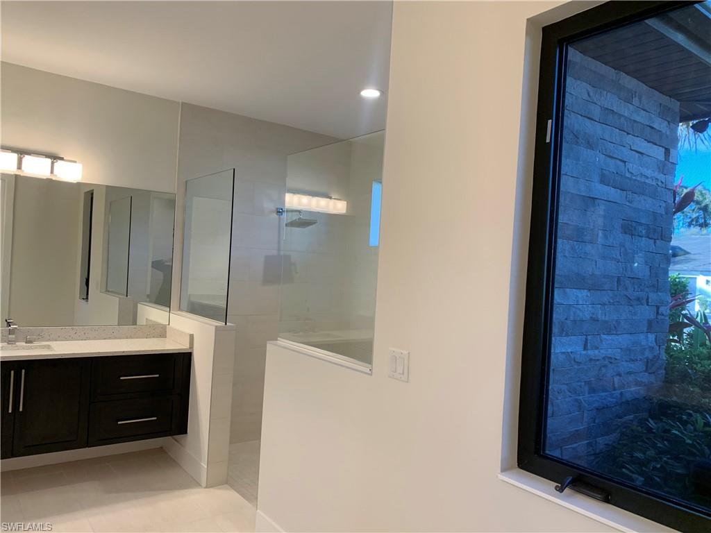 214 Legacy Court Naples, FL 34110 - Photo 30 of 49 a bathroom with a sink and a mirror