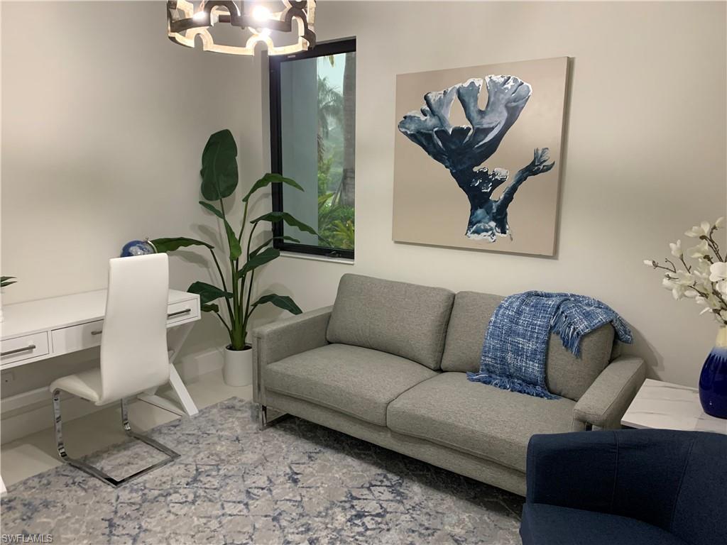 214 Legacy Court Naples, FL 34110 - Photo 48 of 49 a living room with furniture a rug and a chandelier