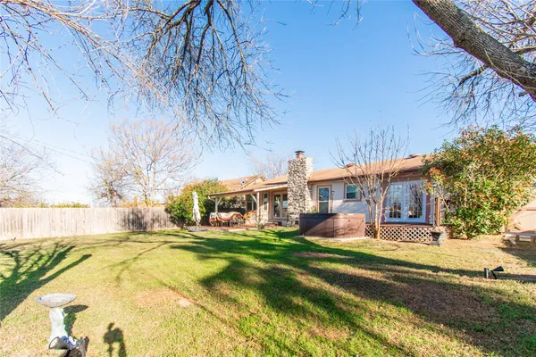 a view of a house with a big yard and large trees