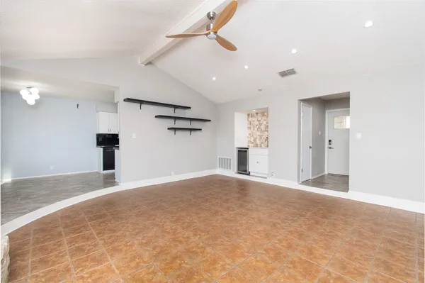 an empty room with closet and windows