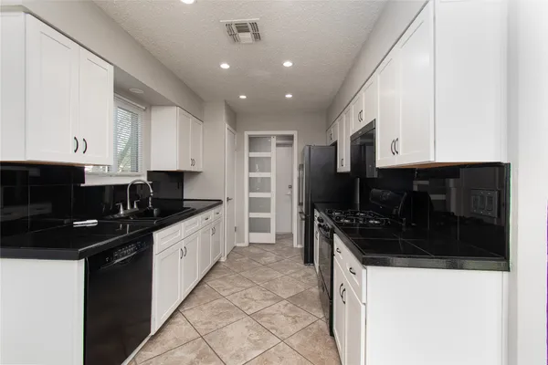 a kitchen with granite countertop a sink and cabinets