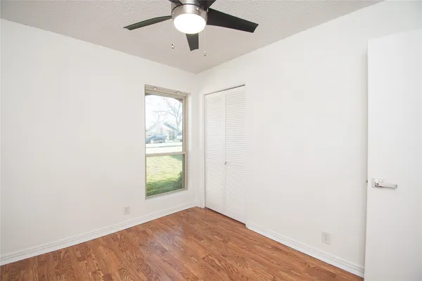an empty room with window and ceiling fan