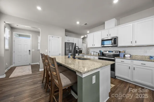 a kitchen with stainless steel appliances granite countertop a stove a sink and a refrigerator