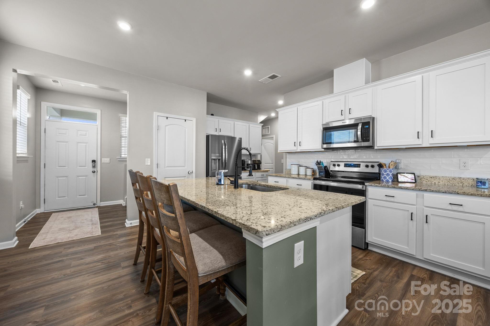 567 Sitka Drive York, SC 29745 - Photo 11 of 40 a kitchen with stainless steel appliances granite countertop a table chairs sink refrigerator and cabinets