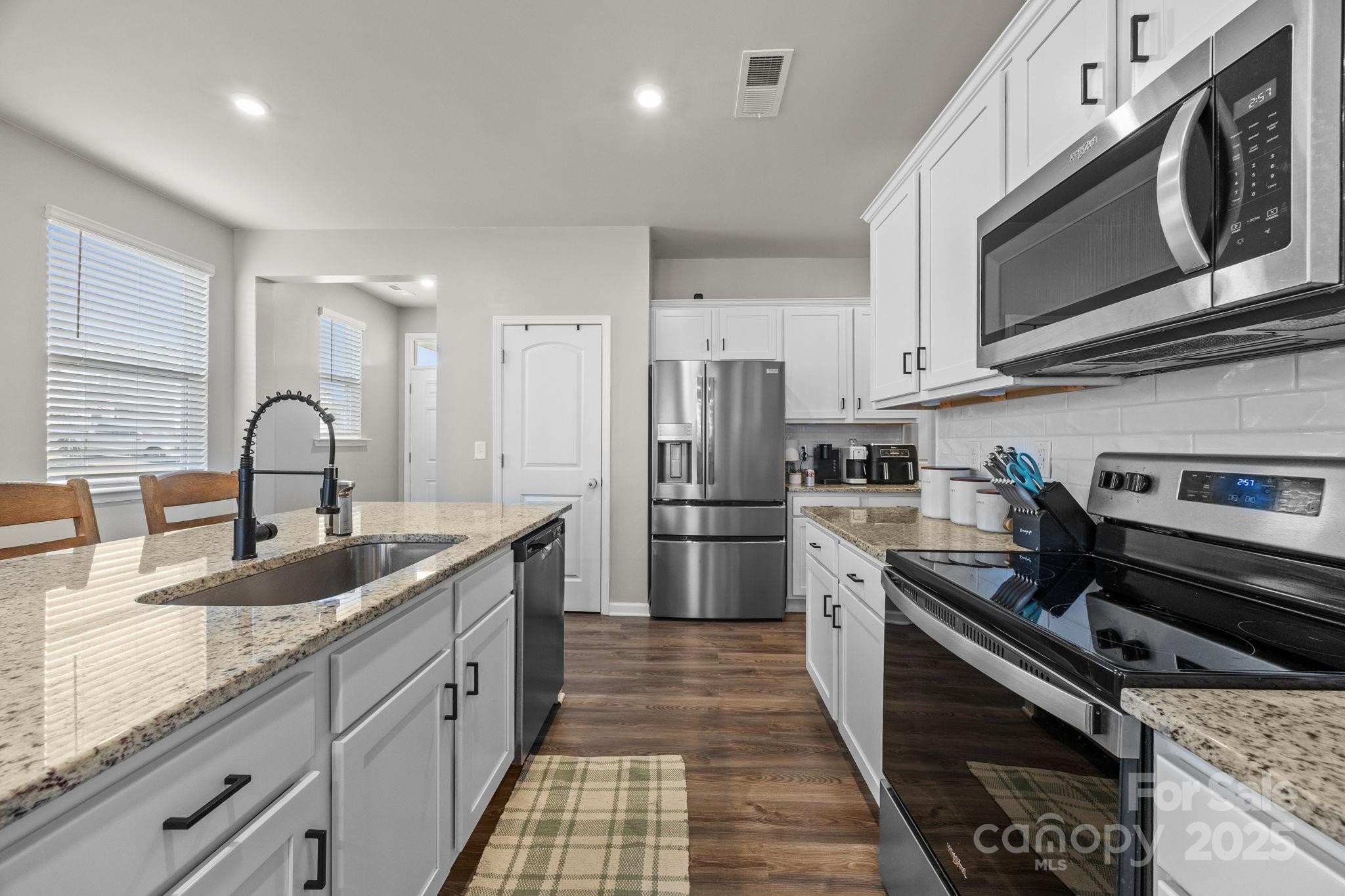 567 Sitka Drive York, SC 29745 - Photo 9 of 40 a kitchen with stainless steel appliances granite countertop a sink stove and refrigerator