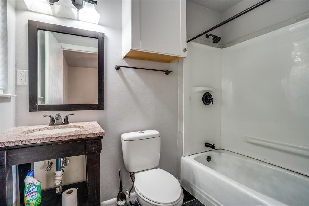 266 West Fulton Street Van Alstyne, TX 75495 - Photo 11 of 13 a bathroom with a toilet sink and mirror