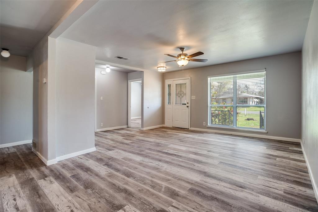 266 West Fulton Street Van Alstyne, TX 75495 - Photo 3 of 13 a view of an empty room with a window and wooden floor