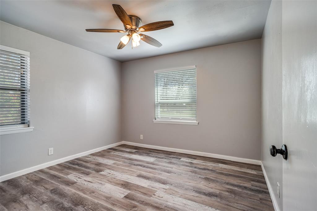 266 West Fulton Street Van Alstyne, TX 75495 - Photo 9 of 13 wooden floor in an empty room with a window