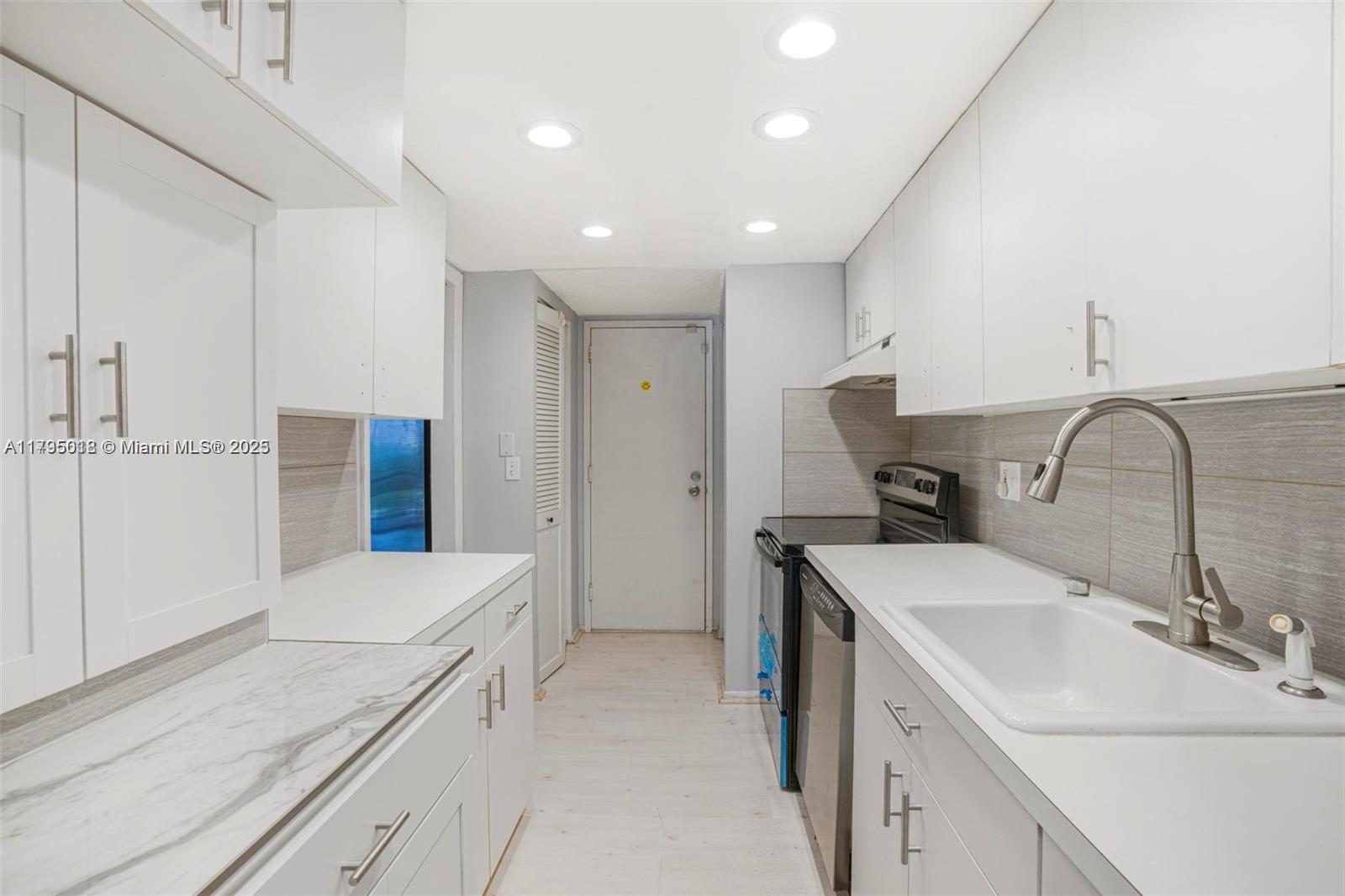 3650 Inverrary Drive, Unit 3P Lauderhill, FL 33319 - Photo 14 of 40 a room with a sink a washer and dryer