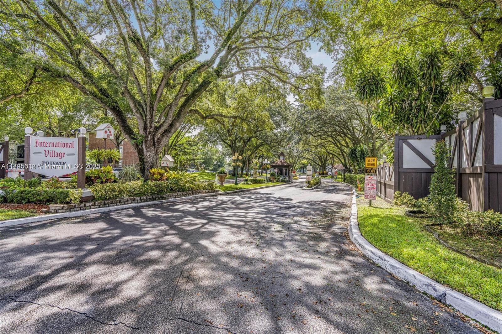 3650 Inverrary Drive, Unit 3P Lauderhill, FL 33319 - Photo 2 of 40 a pathway of a house with a yard and large trees