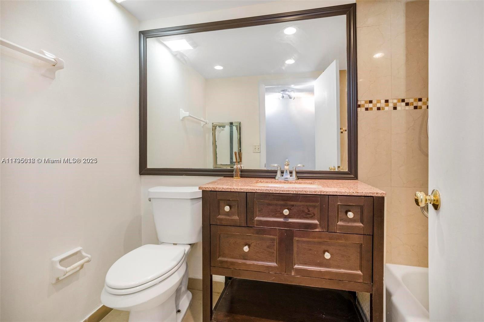 3650 Inverrary Drive, Unit 3P Lauderhill, FL 33319 - Photo 21 of 40 a bathroom with a toilet a sink and mirror