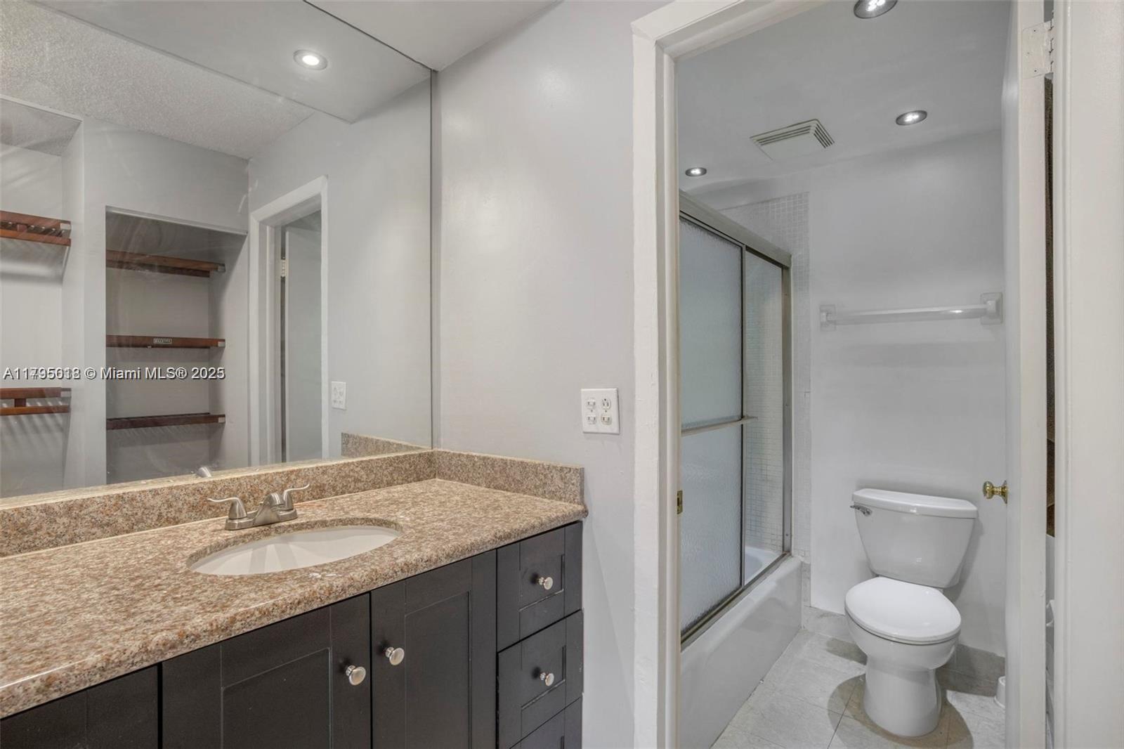 3650 Inverrary Drive, Unit 3P Lauderhill, FL 33319 - Photo 25 of 40 a bathroom with a granite countertop sink toilet and shower