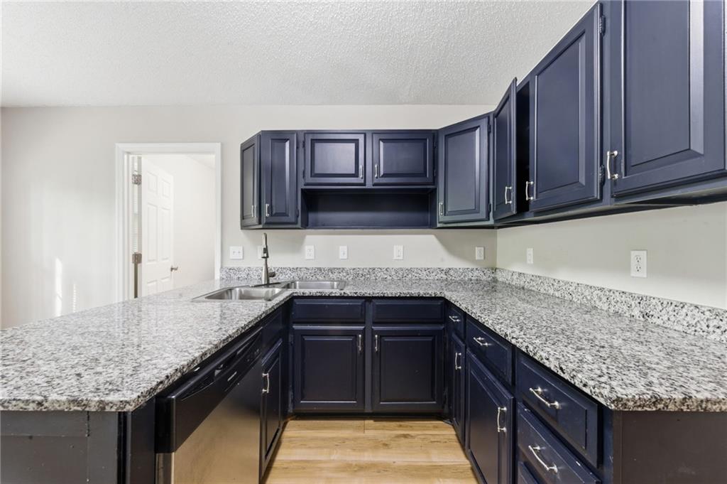 5017 Sandyhook Court Northwest Acworth, GA 30102 - Photo 20 of 43 a kitchen with granite countertop a sink and cabinets