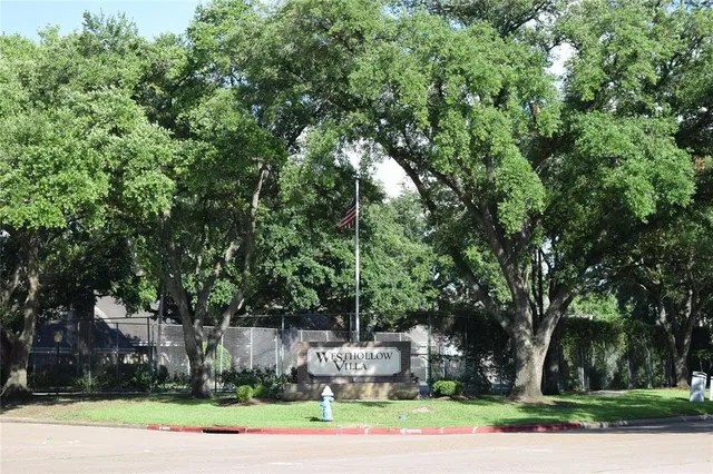 a front view of a house with a yard and large trees