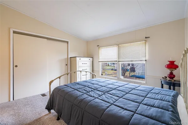 a bed sitting in a bedroom next to a window