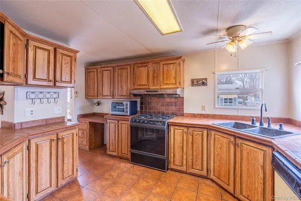 a kitchen with stainless steel appliances granite countertop a stove top oven a sink dishwasher and cabinets with wooden floor